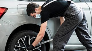 News Mechaniker überprüft Autoreifen in moderner Werkstatt