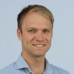 Bozen Land Porträt eines jungen Mannes mit blauem Hemd vor hellem Hintergrund