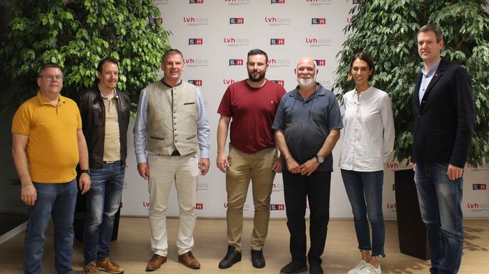 Tapezierer/innen-Raumausstatter/innen: Neuer Obmann und Berufsbeirat Sieben Personen stehen vor einer Wand mit LVH- und Genfion-Logos