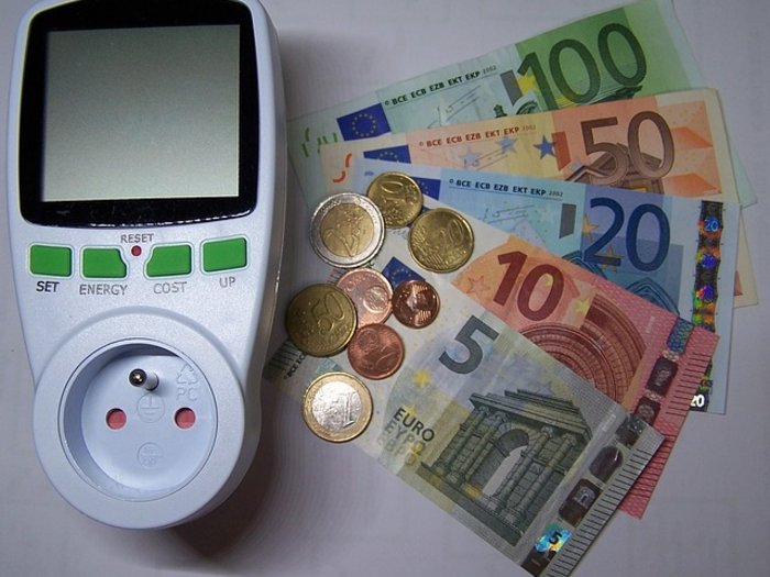 Extreme Strompreise für Unternehmen nicht nachvollziehbar Energiekostenmessgerät neben Euro-Geldscheinen und Münzen