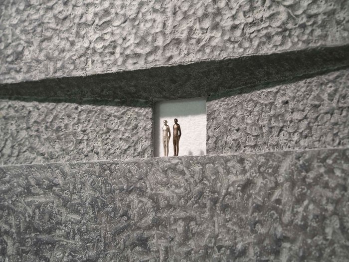 Die 31. UNIKA-Kunstmesse eröffnet in St. Ulrich Zwei kleine Figuren vor einer strukturierten grauen Wand mit Schatten