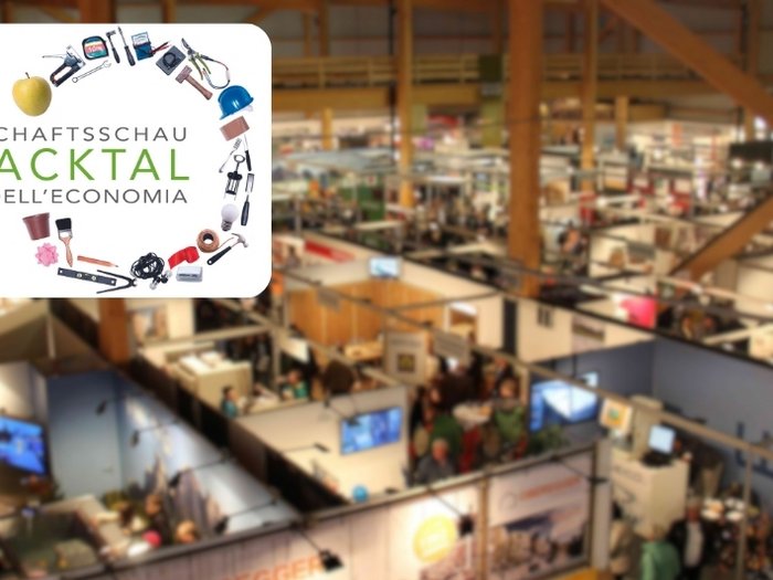 Fiera dell’Economia Val d’Isarco 2024 Stand fiera con logo Fiera dell'Economia Eisacktal e visitatori nella sala espositiva