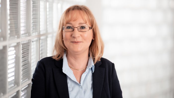 Frauen im lvh: Neue Förderung lässt aufatmen Frau mit blonden Haaren und Brille vor einer Glassteinwand