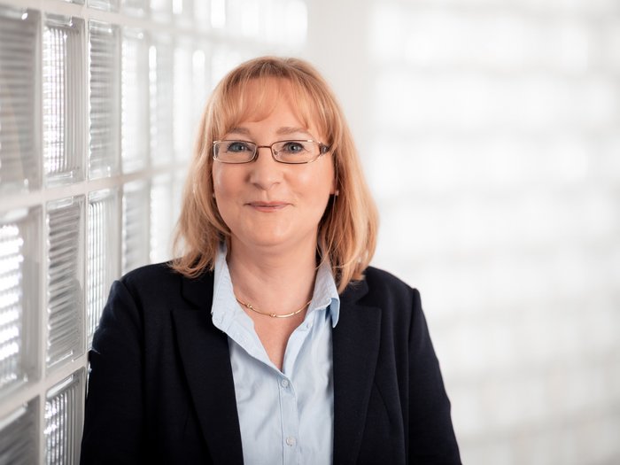 Frauen im lvh: Neue Förderung lässt aufatmen Frau mit blonden Haaren und Brille vor einer Glassteinwand