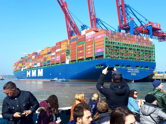 Die Althandwerker besuchen Hamburg Viele Menschen fotografieren ein großes Containerschiff mit bunten Container in einem Hafen