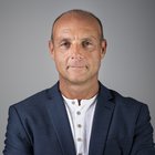 Heizungs-, Lüftungs- und Sanitärtechniker Porträt eines mittelalten Mannes in weißem Hemd und blauem Sakko vor grauem Hintergrund