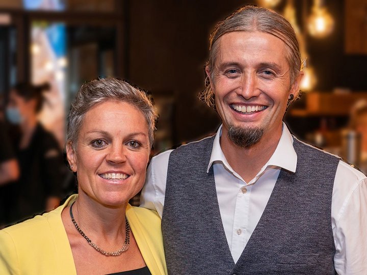 Lobis Böden Zwei lächelnde Personen in formeller Kleidung in einem Innenraum