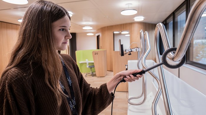 Talentcenter Bozen: positive Bilanz nach den ersten sechs Monaten Frau untersucht mit Gerät gebogene Metallrohre in modernem Büro