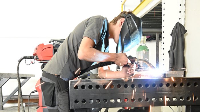 Mettersi all'opera con mani e cuore: l'apprendista fabbro Jakob Lantschner racconta la sua formazione artigianale Operaio che salda metallo in officina con casco protettivo