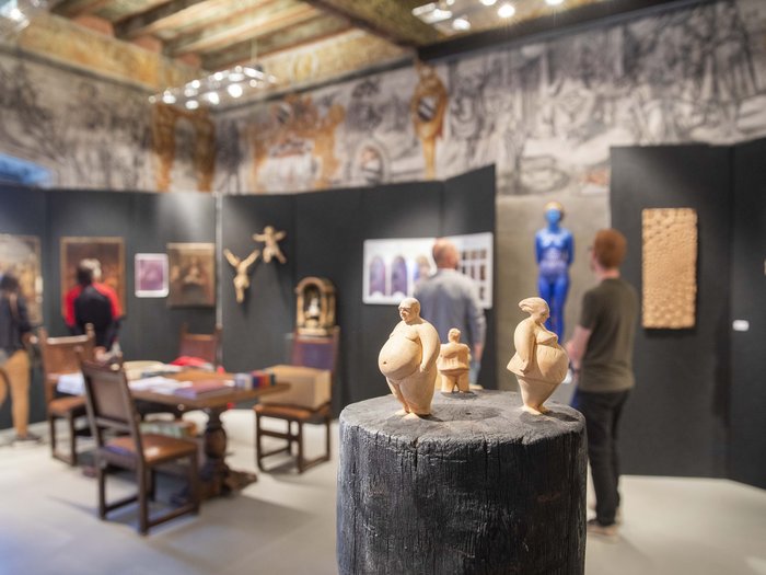 Colori nell’artigianato artistico Diverse opere d'arte e sculture in una mostra museale con visitatori