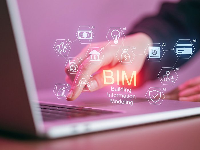Bauen wird digital – und verbindlich: Neue BIM-Leitlinien erhöhen den Druck auf die Branche Hand tippt auf Laptop mit BIM und verschiedenen AI Symbolen