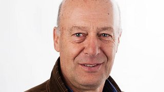 News Porträt eines älteren Mannes mit hellbrauner Jacke vor weißem Hintergrund