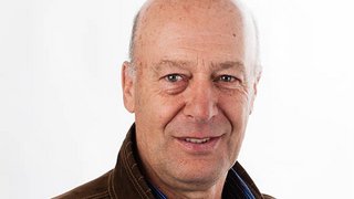 News Porträt eines älteren Mannes mit hellbrauner Jacke vor weißem Hintergrund