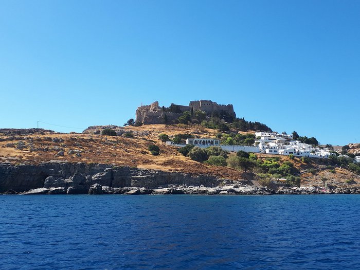 Althandwerker Rhodos 2022 © lvh.apa Blick vom Meer auf Hügel mit Burg und weißen Häusern unter klarem blauem Himmel