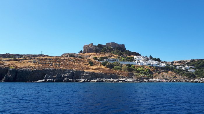 Althandwerker Rhodos 2022 © lvh.apa Blick vom Meer auf Hügel mit Burg und weißen Häusern unter klarem blauem Himmel