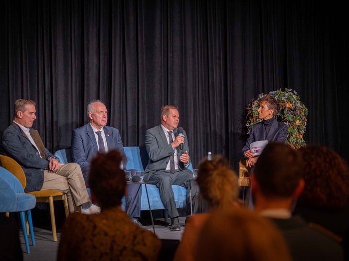 Wachstum im Gleichgewicht Podiumsdiskussion mit vier Personen vor Publikum vor schwarzem Vorhang