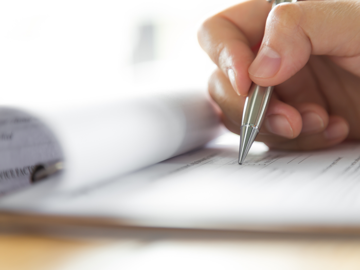 Appalti pubblici e sostenibilità Mano scrive con penna d'argento su modulo su cartellina