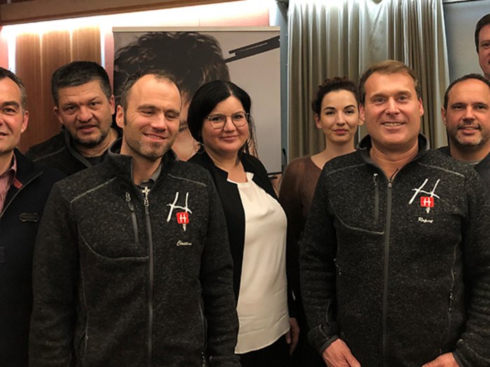 Kein Gemeinderat ohne Handwerk Gruppe von acht Personen steht in einem Raum vor einer Gardine und einem Plakat