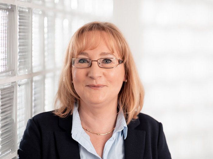 Seniorenwohnheim im Wipptal: Aufträge im Sinne der KMUs vergeben Frau mit Brille und Blazer vor hellem Hintergrund lächelnd