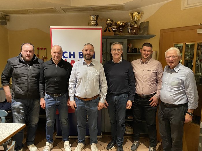 Sluderno: eletto un nuovo presidente comunale Sei uomini in piedi davanti a uno striscione e scaffali con trofei in una stanza