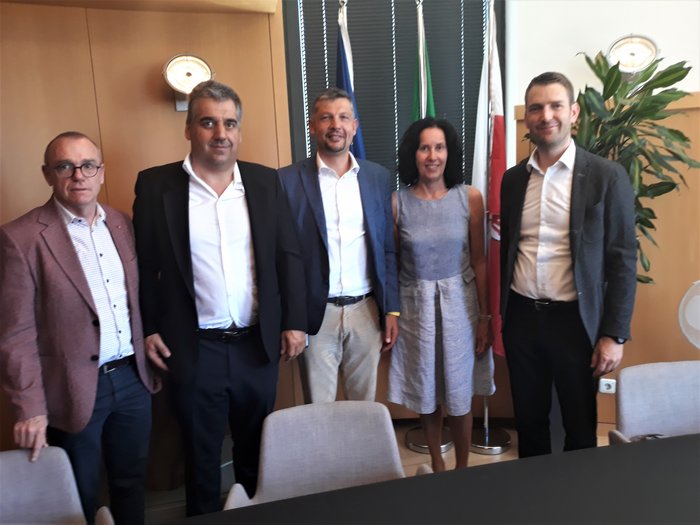 Autonoleggiatori: un confronto necessario Cinque persone in abiti da lavoro davanti a bandiere in ufficio