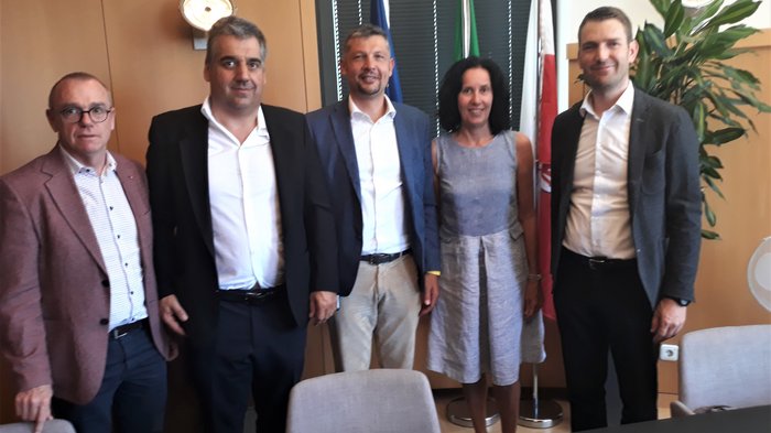 Autonoleggiatori: un confronto necessario Cinque persone in abiti da lavoro davanti a bandiere in ufficio