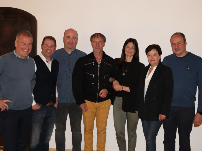 Gemeinsame Jahresversammlung: Innovation, Ausbildung und Zusammenarbeit im Fokus Gruppe von sieben Personen vor hellem Hintergrund, lächelnd und casual gekleidet