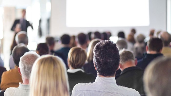 Inforeihe „Neue Urbanistik in Südtirol – Lust oder Frust“ Publikum schaut einem Vortragenden in einem Seminarraum zu