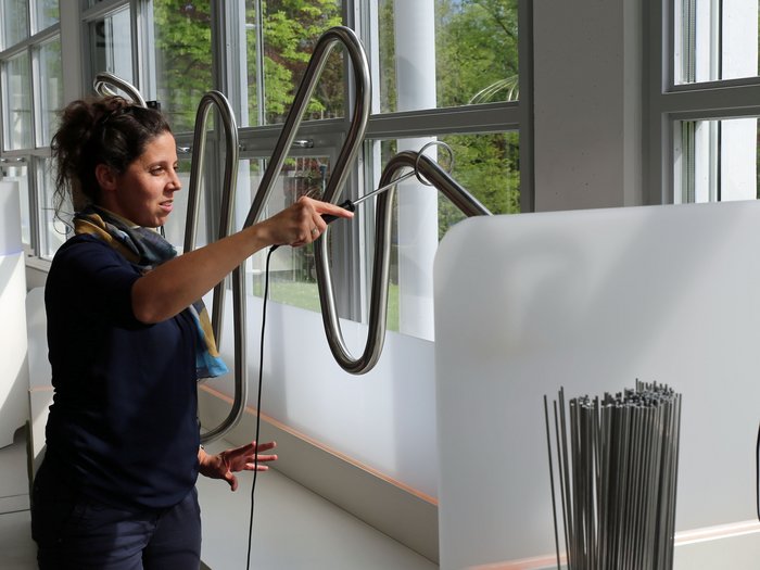 La delegazione altoatesina ha visitato il Talentcenter di Graz Donna suona uno strumento musicale metallico vicino a una finestra