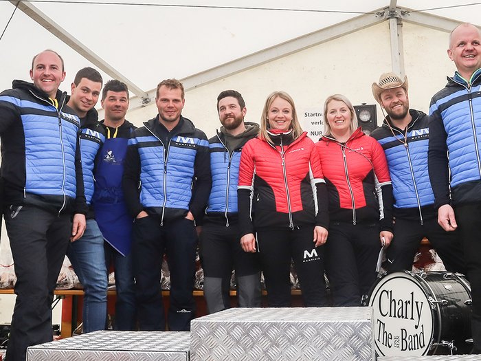 Große Teilnahme beim landesweiten Wintersportfest der Handwerker Gruppe von zehn Personen in bunten Jacken bei Veranstaltung im Zelt