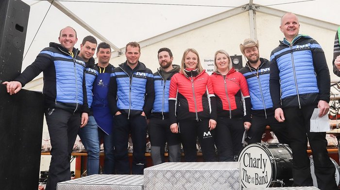 Große Teilnahme beim landesweiten Wintersportfest der Handwerker Gruppe von zehn Personen in bunten Jacken bei Veranstaltung im Zelt