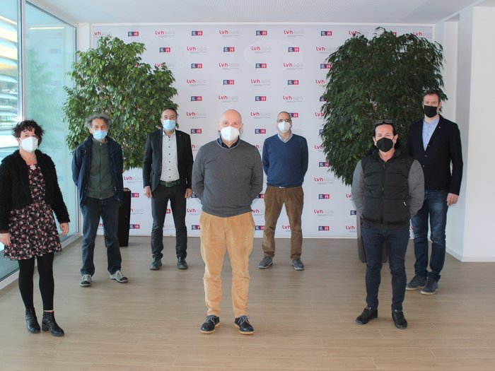 Wichtige Neuigkeiten in Bezug auf die Bilaterale Körperschaft und den Lehrlingsvertrag im Handwerk Gruppe von sieben Personen mit Masken stehen in einem Raum vor einer LVH-APA-Wand