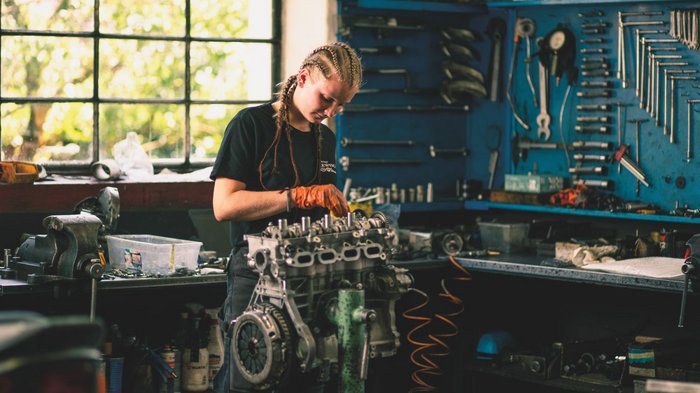 WorldSkills a Lione: presto il via! Una donna lavora con guanti arancioni su un motore in officina