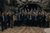 Home Un folto gruppo posa in una grotta rocciosa per una foto di gruppo