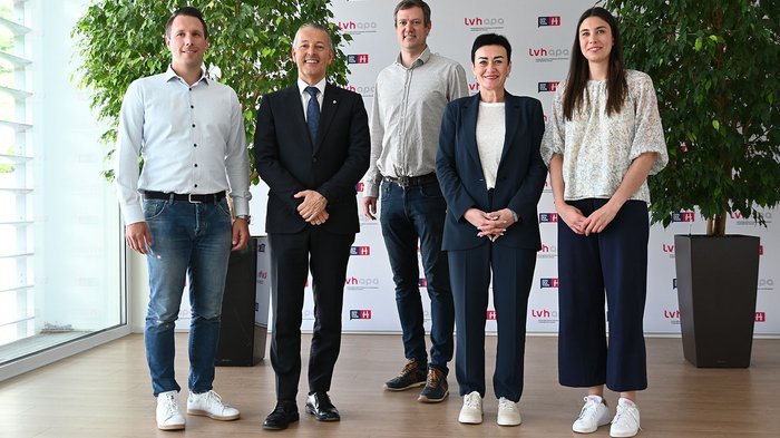 Wohnen muss leistbar sein! Herausforderungen und Lösungsansätze in Südtirol Fünf Personen stehen vor Wand mit LVH APA-Logos, lächelnd und formell gekleidet