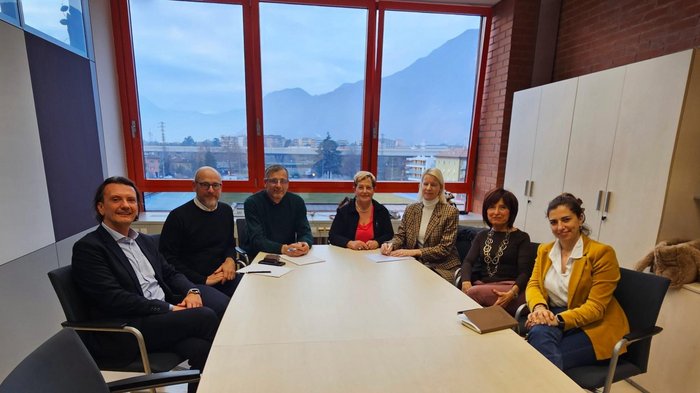 Formazione Professionale: una rete forte a sostegno dell’apprendistato Gruppo di sette persone sedute intorno a un tavolo in una riunione in ufficio con grande finestra