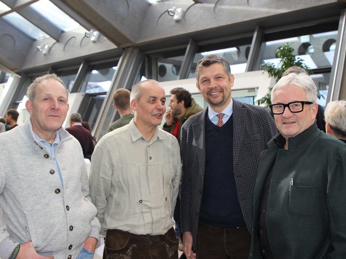 Grande successo per il convegno sulle costruzioni in legno Quattro uomini in una stanza luminosa durante un evento in conversazione