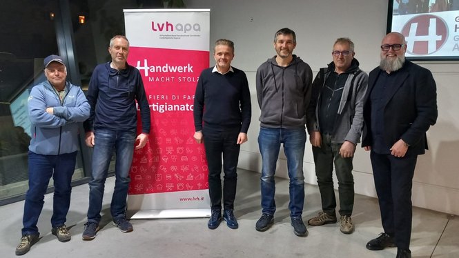 Sieben Männer stehen vor einem Banner des Handwerksverbands lvh appa
