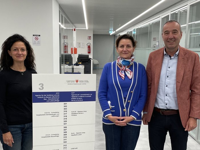 Incontro ACP Tre persone in ufficio accanto a un cartello con informazioni ufficiali