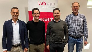 News Vier Männer lächeln vor einem lvhapa-Banner