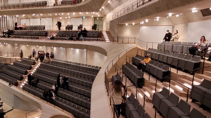 Die Althandwerker besuchen Hamburg Moderner Konzertsaal mit mehreren Sitzreihen und warmen Deckenlichtern