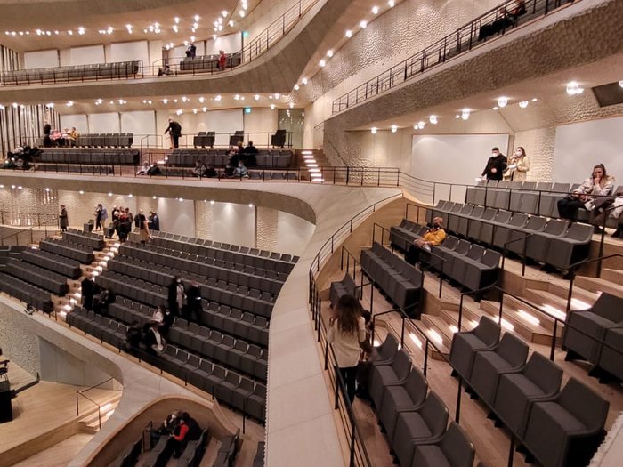 Die Althandwerker besuchen Hamburg Moderner Konzertsaal mit mehreren Sitzreihen und warmen Deckenlichtern