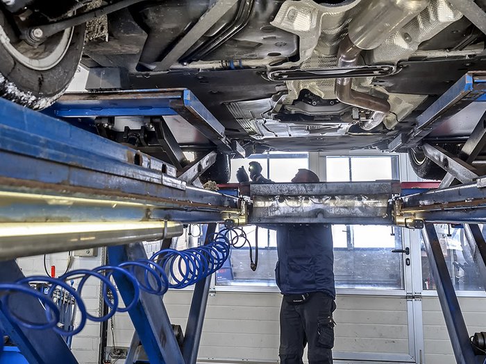 KFZ-Sektor: Kunden dürfen selbst in die nächste Werkstatt fahren Mechaniker inspiziert Fahrzeugunterseite in Autowerkstatt auf Hebebühne