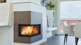 News Moderne Ecke mit brennendem Kamin, Wanduhren und Essbereich mit Aussicht