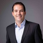 Diritto ambientale Uomo sorridente con giacca nera davanti a sfondo grigio