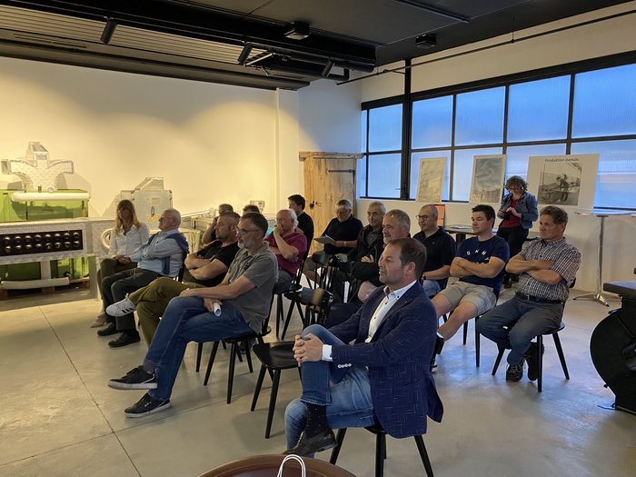 Handwerk gestaltet mit! Gruppe von Personen sitzt auf Stühlen und hört in einem hellen Raum aufmerksam zu