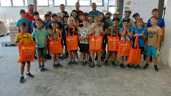 Handwerk zum Anfassen: KidsAcademy begeistert Kinder in Schlanders Gruppenfoto von Kindern mit orangen Terzer-Taschen in einer Halle