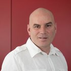 Schuhmacher Porträt eines Mannes mit weißem Hemd vor rotem Hintergrund