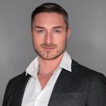 Das lvh-Team Porträt eines Mannes mit blauem Blick in weißem Hemd und schwarzem Sakko vor grauem Hintergrund