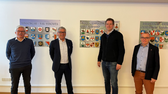 PNRR: dare priorità alle ditte artigiane locali Quattro uomini stanno davanti a una parete con stemmi di Vinschgau, Burgraviato e Oltradige